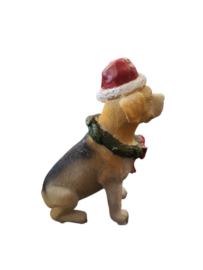 Labrador puppy met een kerstmuts en een kerstkrans